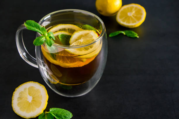 istock Herbal tea with lemon and mint on dark background. Delicious drink for relaxation and refreshment 1345740452