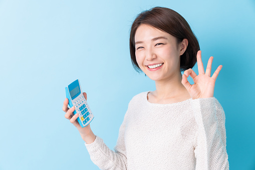 Woman of the smile having an electronic calculator
