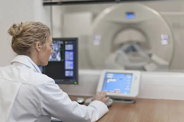 Photo of Doctor operating CT scanner in hospital