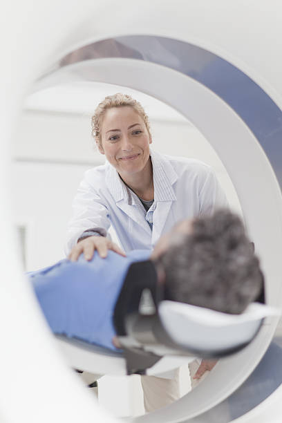 Doctor preparing patient for CT scanner  mri scanner stock pictures, royalty-free photos & images