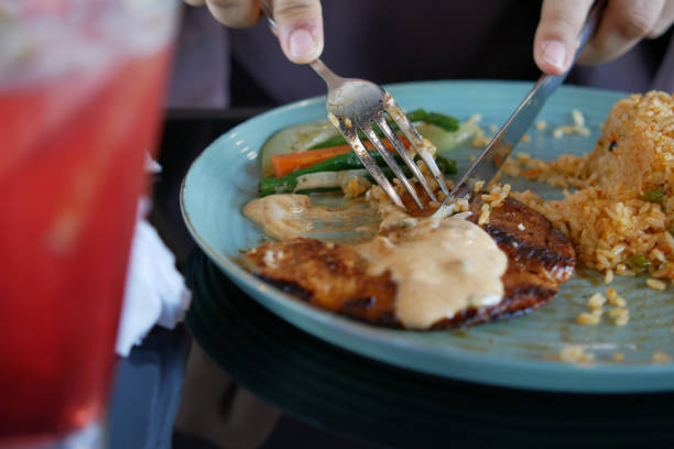 istock cutting grill chicken , with knife and fork with rice and salad on plate 1345753818