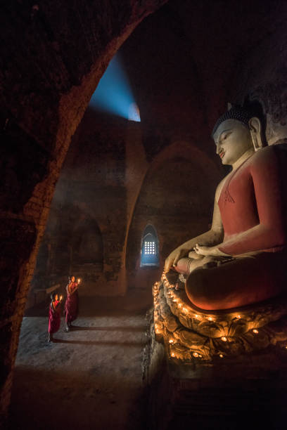 istock Myanmar monk praying with candle light in a Buddhist temple 1345763595