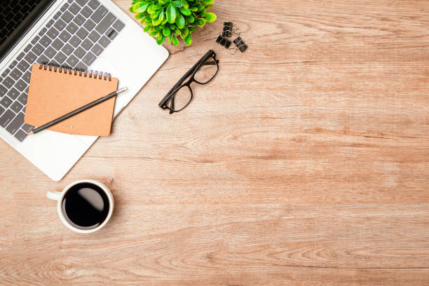 istock Work from home. desk office with laptop, blank notepad, coffee cup and pen on wood table. Flat lay top view copy spce. 1345765502