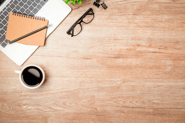 istock Work from home. desk office with laptop, blank notepad, coffee cup and pen on wood table. Flat lay top view copy spce. 1345765503