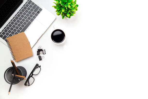 istock White office desk table with blank notebook, computer keyboard and other office supplies. Top view with copy space, flat lay. 1345765508