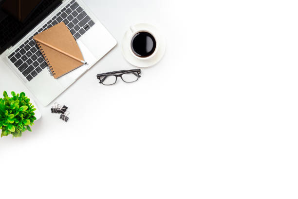 istock White office desk table with blank notebook, computer keyboard and other office supplies. Top view with copy space, flat lay. 1345765511