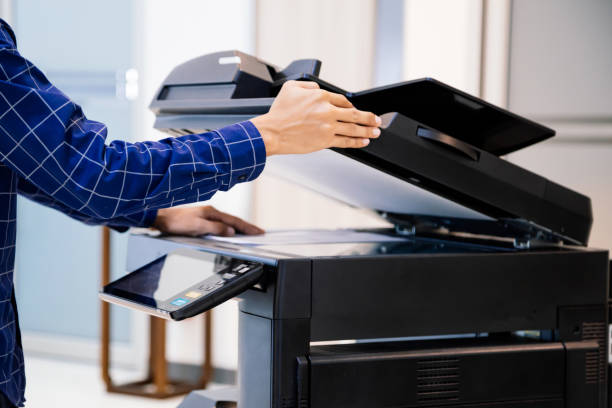 istock Businessmen press button on the panel for using photocopier or printer for printout and scanning document paper at office. 1345765521