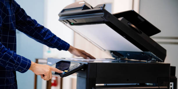 istock Businessmen press button on the panel for using photocopier or printer for printout and scanning document paper at office. 1345765527