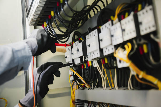 los ingenieros eléctricos prueban las instalaciones eléctricas y el cableado en relés de protección, midiéndolos con un multímetro. - aparatos electricos fotografías e imágenes de stock