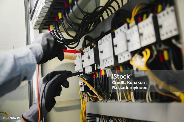 Electrical Engineers Test Electrical Installations And Wiring On Protective Relays Measuring Them With A Multimeter Stock Photo - Download Image Now