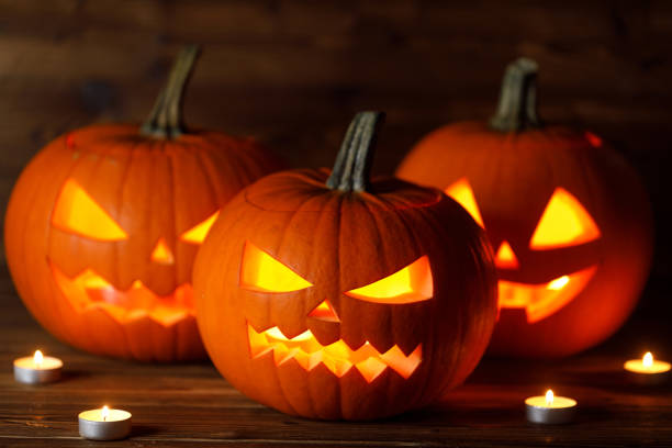 istock Three Halloween Pumpkins and candles 1345769069