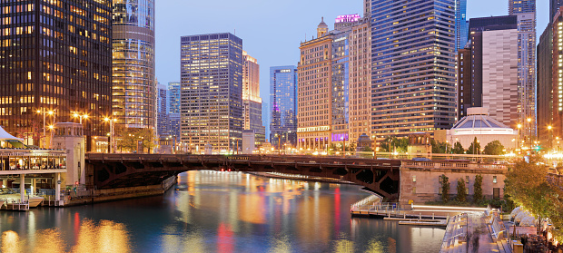 Night time panoramic view of the Chicago river, the skyscrapers that line river and one of the bridges that cross it.