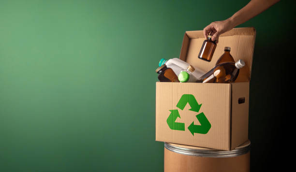 istock Climate and Environmentally Conservation Concept. Recycling Corrugated Box with Full of Plastic and Glass Bottle against the Green Wall. Zero Waste, Reduce Plastic. Environment, Ecology Care and Renewable 1345771200