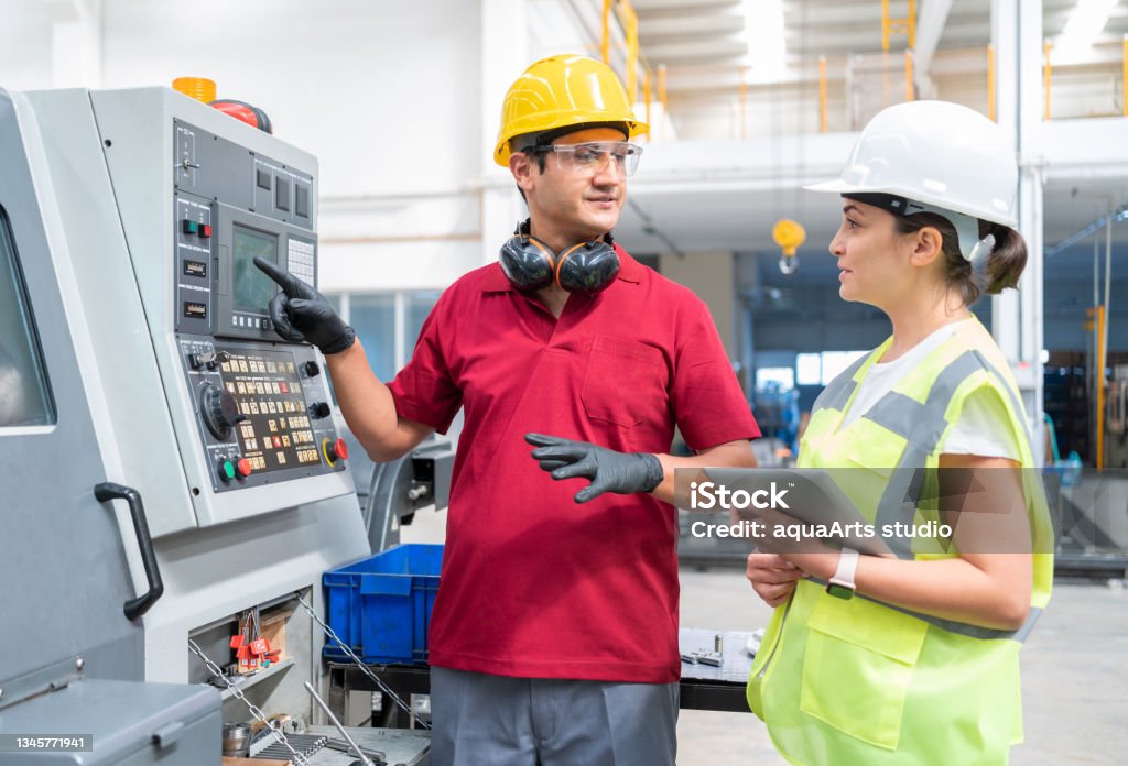 Female Engineer And Worker Discussing Production At Factory Engineer Stock Photo