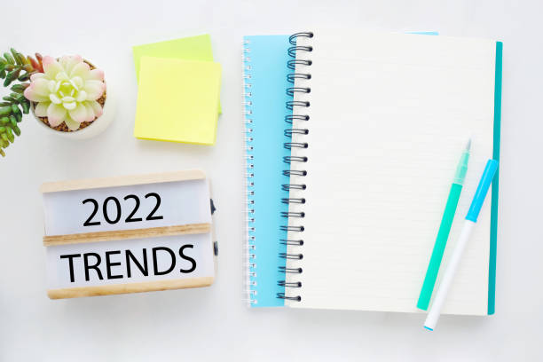 istock 2022 on wood box, blank notebook paper on white marble table background, 2019 new year mock up, template with copy space for text, top view 1345774250