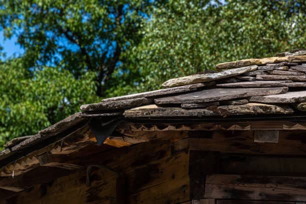 istock Old stone tiles for roof covered with moss 1345777297