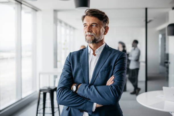 istock Smartly-dressed businessman looking through the window 1345778661