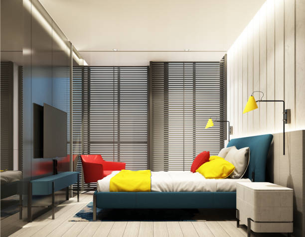 buntes schlafzimmer inneneinrichtung mit feature wand in rot blau gelb und grau ton mit tv-schrank und bett, sessel auf holzboden, decke und holzjalousie an großem fenster 3d-putz - red bed stock-fotos und bilder