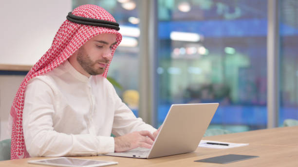 istock Serious Arab Businessman Working on Laptop in Office 1345782484