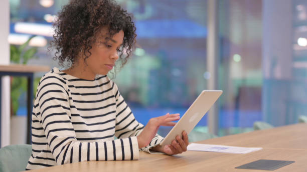 istock Serious African Woman using Tablet in Office 1345784524