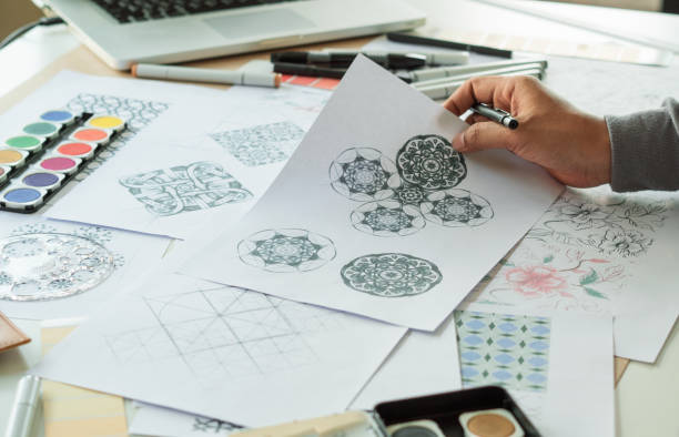 istock Designer designing drawing sketch pattern geometric flower seamless wallpaper fabric textile fashion industry. artistic design studio. 1345788995