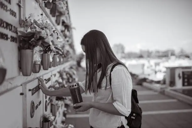 Photo of Young woman grieving at the memorial cemetery