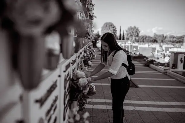 Photo of Young woman visiting the memorial cemetery