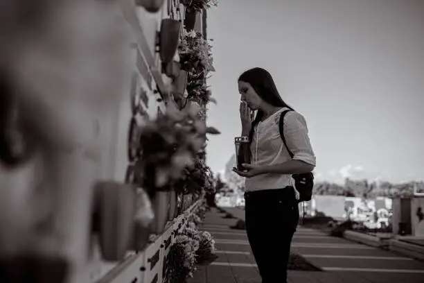 Photo of Black and white photo of an young woman visiting memorial cemetery