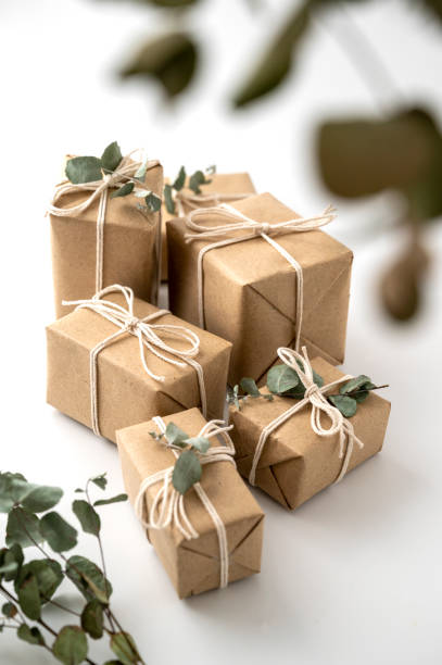 istock Christmas rustic present gift boxes isolated on a white background. Craft paper and eucalyptus leaves. 1345797214
