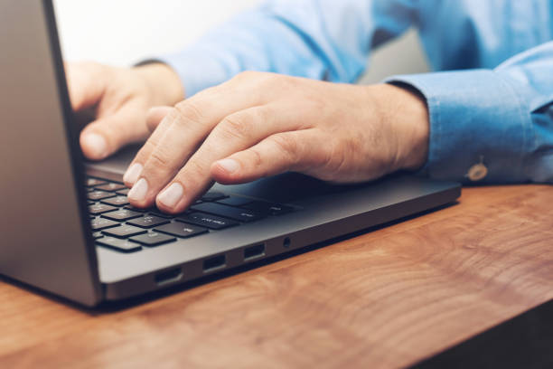 istock Male hands typing on a laptop keyboard, close-up view 1345800439