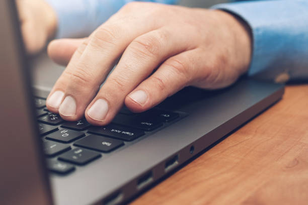 istock Male hands typing on a laptop keyboard, close-up view 1345800440