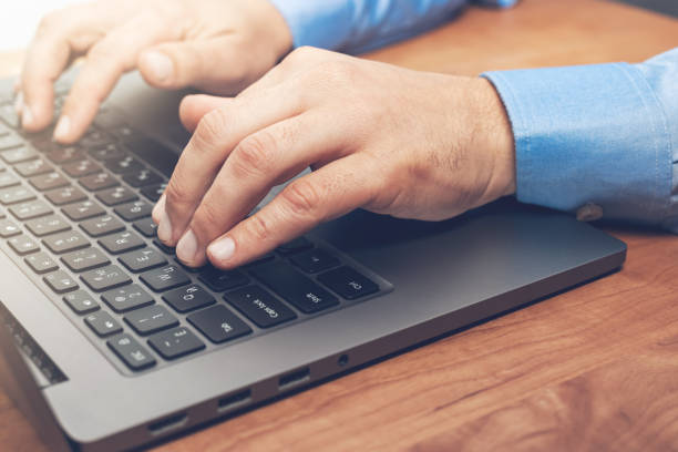 istock Male hands typing on a laptop keyboard, close-up view 1345800443