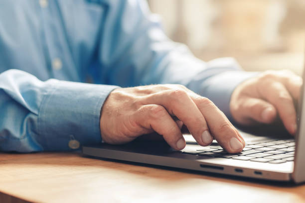 istock Male hands typing on a laptop keyboard, close-up view 1345800487