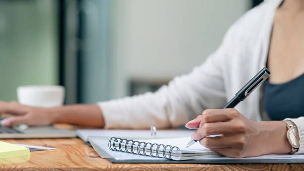 istock Closeup of woman's hand writing on notebook, 1345802248