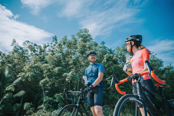 istock asian chinese couple cyclist taking a break drinking water during weekend morning road cycling at rural scene 1345803203
