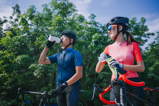 istock asian chinese couple cyclist taking a break drinking water during weekend morning road cycling at rural scene 1345803336