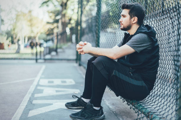 istock Handsome man resting after playing basketball 1345804832