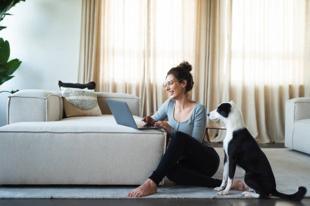 istock Happy Woman Laughing While Working From Home with Puppy Dog 1345805490