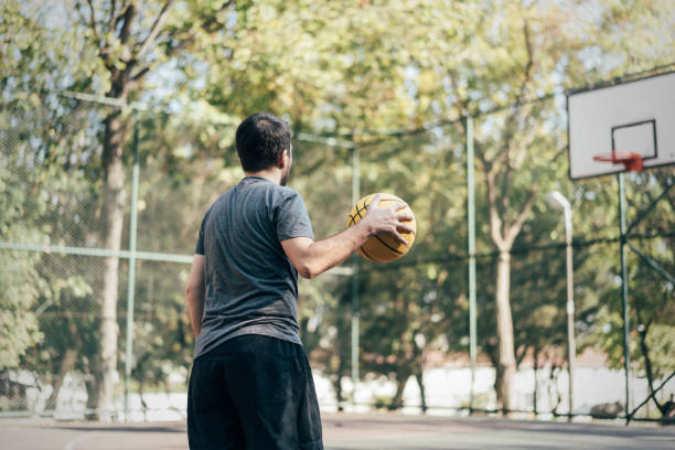 istock Man playing basketball at public park 1345806377