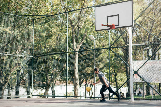 istock Man playing basketball at public park 1345806380
