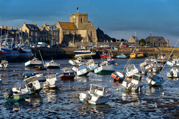 Port of Barfleur in France Port at low tide at the end of the sunny day and church of Saint-Nicolas of Barfleur, a commune in the peninsula of Cotentin in the Manche departmentin Lower Normandy in north-western France low tide stock pictures, royalty-free photos & images