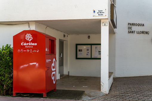 Palmanova, Spain; october 03 2021: Container to deposit used clothes for the Christian association Caritas, wich recycles them and sends them to people in need. Parish af Sant Llorens, Mallorca island