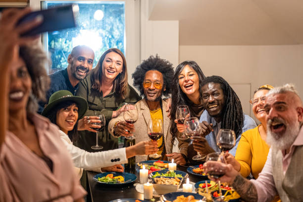friends toasting and making selfie at dinner party, large group of people having fun and celebrating themselves, social gathering and friendship concept, celebration toast - eating people group of people home interior imagens e fotografias de stock
