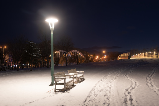Park bench on a snowy winter's night