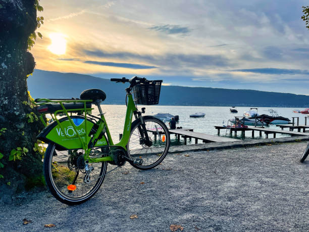 aluguel de bicicleta elétrica na borda pôr do sol lago annecy - water surface standing water waters edge water - fotografias e filmes do acervo