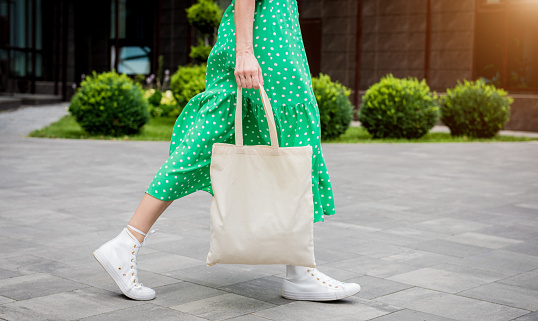 Joven mujer hermosa con bolsa ecológica de lino en el fondo de la ciudad. photo