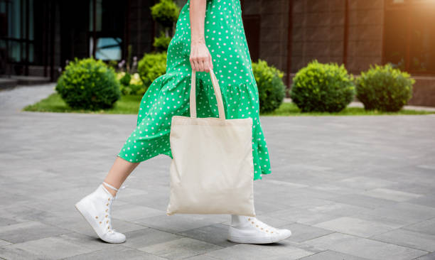 joven mujer hermosa con bolsa ecológica de lino en el fondo de la ciudad. - women bag fotografías e imágenes de stock