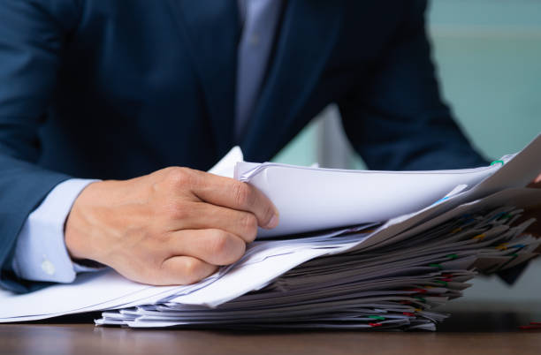 istock Businessman holding document after reading the agreement in office, hand writing. 1345811734