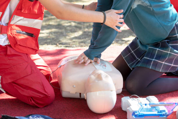First aid and CPR class First aid and CPR training using automated external defibrillator device first aid class stock pictures, royalty-free photos & images