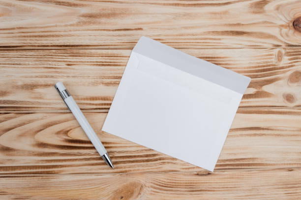 istock Mock up of an empty envelope on a light wood background. Blank paper template for design. Flat lay 1345812660